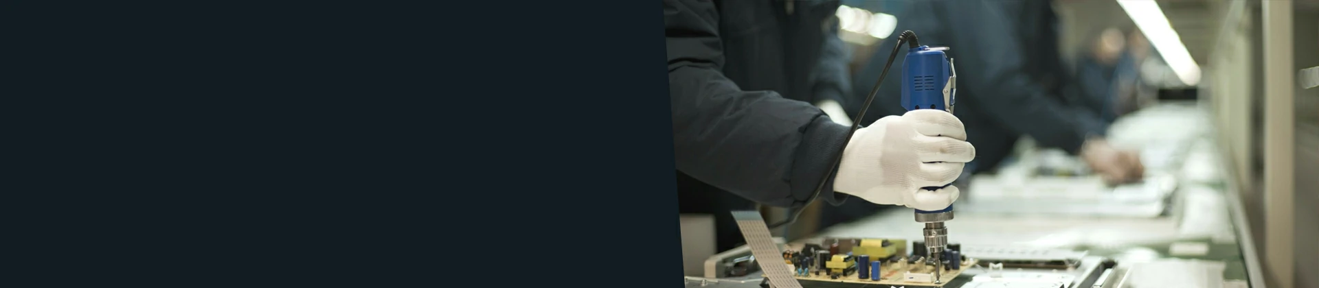 Technician inspecting a PCB board in a cleanroom electronics assembly line with automated inspection equipment