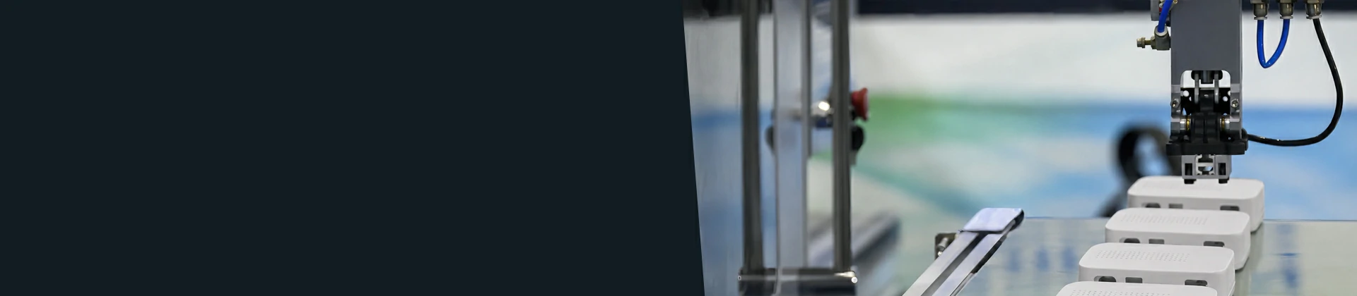 Technician inspecting a plastic electronics enclosure beside an injection molding machine in a cleanroom manufacturing facility
