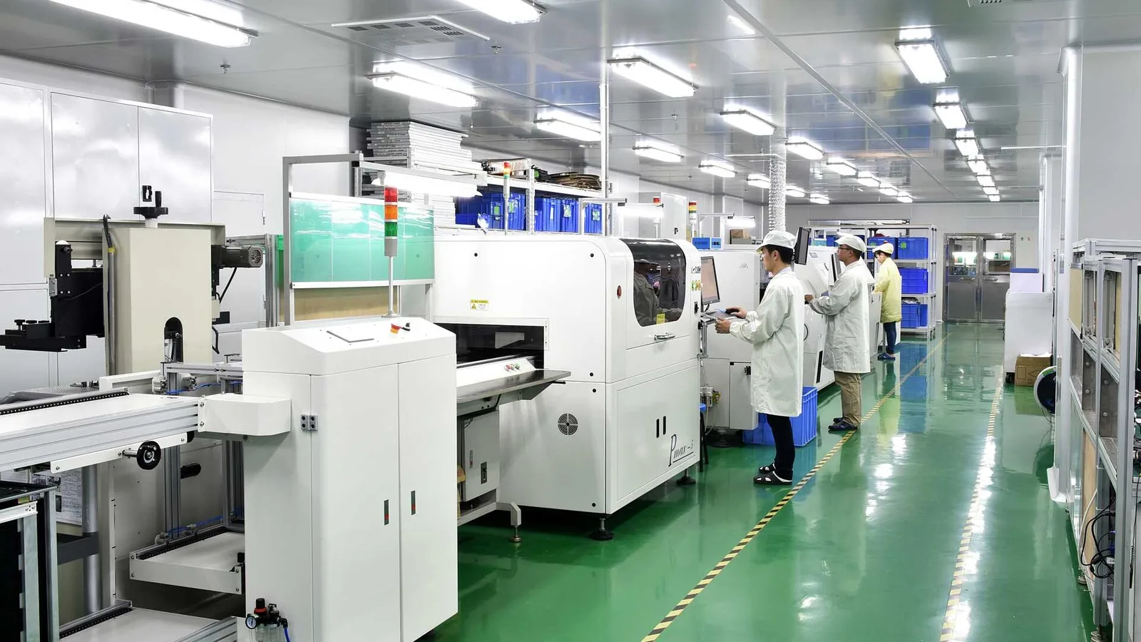 SMT production line with pick-and-place machines and conveyor sections inside a clean electronics factory